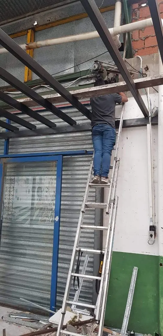 Técnico en escalera trabajando en motor